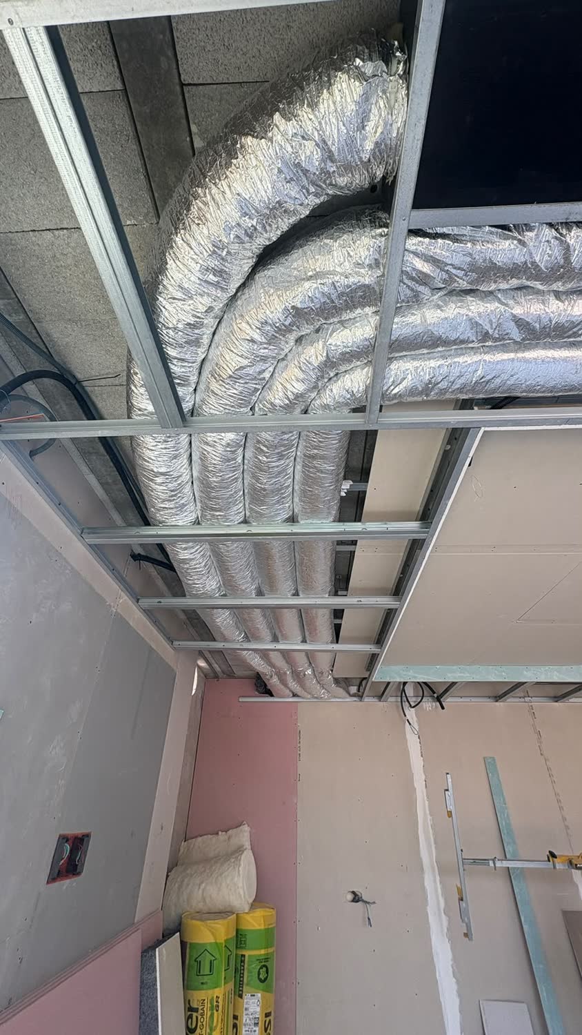 Gaines souples isolées d'une climatisation gainable dans un faux-plafond en chantier
